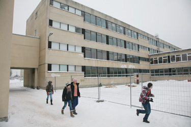 Võru Kreutzwaldi gümnaasiumi õppehoonetel vahetatakse remondi käigus kokku ligi 300 akent. Pildil on kooli õpilased, kes peavad remondi ajal käima õpperuumidest sööklasse läbi hoovi.	 Foto: Võrumaa Teataja