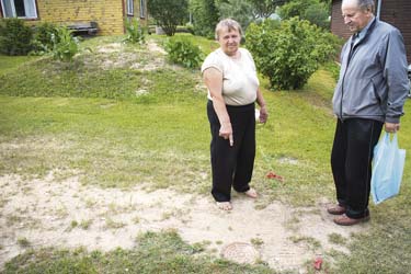 Kose pensionäripaar Helle ja Ants Kõiv liitumispunkti juures, millest vee majja saamine nõuab täiendavalt tuhandeid eurosid. Foto: Võrumaa Teataja