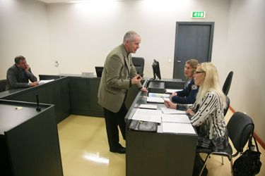 Eile kohtusaalis Elmer Hõrakut (vasakul) esindanud Vambola Olli (esiplaanil) vestlemas keskkonnainspektsiooni esindajate Anneli Huigi ja Katrin Lehtlaga.  Foto: INNO TÄHISMAA