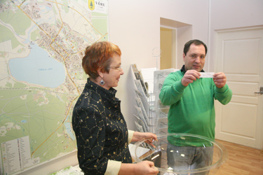 Võru abilinnapea Kersti Kõosaar ja linnapea Jüri Kaver neljapäeval linnavalitsuse infosaalis sissekirjutusauhinna saajat välja loosimas.     Foto: INNO TÄHISMAA