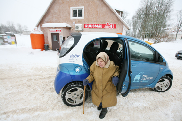 Haanja valla elanik Malle astub Ruusmäel elektriautost välja, et minna poodi süüa ostma. Foto: INNO TÄHISMAA