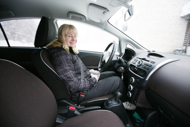 Haanja valla sotsiaaltöö spetsialist Marve Kõiv elektriauto „lisavarustusega”: soojade riiete ja  kinnastega.   Fotod: INNO TÄHISMAA
