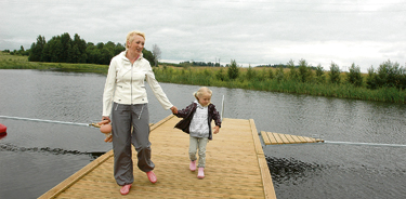 Anne-Ly Võlli koos tütre Aleksandraga Voore paisjärve kaldale rajatud paadisillal. Noorteküla krundid jäävad järvest umbes 100 meetri kaugusele.     Foto: ANATOLI MAKAREVITŠ