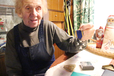 Karin Laine näitab oma tädile kuulunud Kaitseliidu Valgeristi, mis käis koos Kariniga Siberis ära. Foto: INNO TÄHISMAA