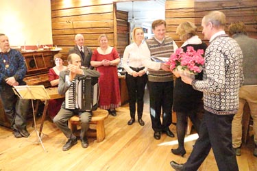 Metsavenna kohviku peremees Meelis Mõttus ja perenaine Marianne Mõttus (pildil keskel) võtmas vastu tervitusi Mõniste valla esindajatelt. Vasakul Mõniste kapell. Foto: INNO TÄHISMAA