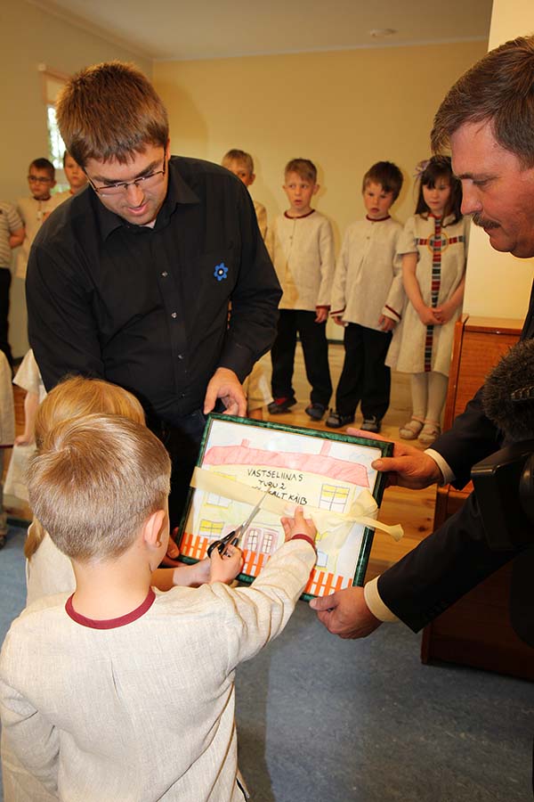 Renoveeritud lasteaia avamise puhul toimus traditsiooniline lindi läbilõikamine hoopis laste joonistatud pildi kohal, mis hiljem kingiti Vastseliina vallavanemale Raul Tohvile.  Foto: BIRGIT PETTAI 