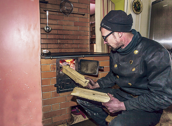 Meisterkorstnapühkija Aigar Kuus ütles Palometsas pliidi alla tuld tehes, et puu peab kuiv olema ning küttekollet ei tohi üle kütta ega järelevalveta jätta.  Foto: ANDREI JAVNAŠAN