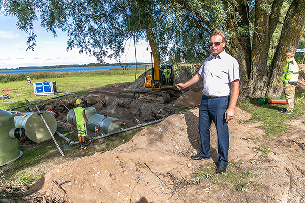Võru linnapea Anti Allas näitab Tamula järve äärsele haljasalale paigutatud sademevete puhastamiseks mõeldud õli-liiva püüdurkaevu. Foto: FOTOSFERA / ANDREI JAVNAŠAN