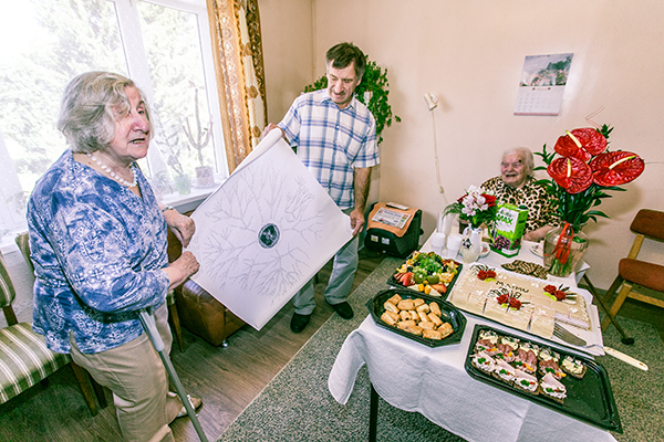 Helju Kalme ja Udo Tell näitavad külalistele juubilari tehtud sugupuud. Foto: ANDREI JAVNAŠAN