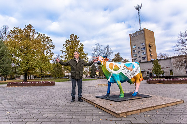 Ülo Eliste eile hommikul Tartu kõrgema kunstikooli skulptuuriosakonna meistri Lauri Tamme ja kunstnik Ülle Ottokari loodud piimalehma skulptuuriga, millelt tasub otsida märksõnu, pilti teha ning maitsvaid auhindu võita.  Foto: ANDREI JAVNAŠAN
