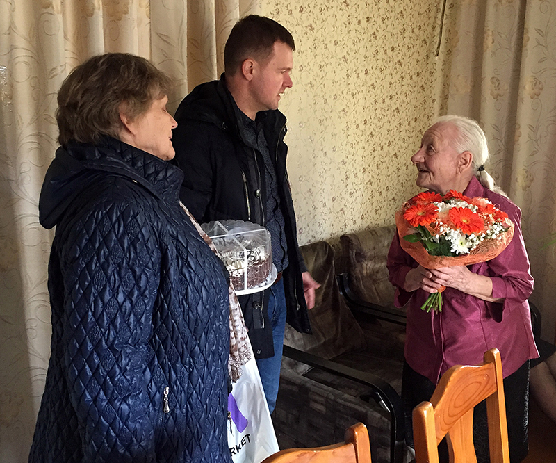 Juubilar Aino Vaidla võtmas vastu õnnesoove abivallavanem Kalmer Puusepalt ja sotsiaaltööspetsialist Maret Tarrendilt. Foto: KADI ANNOM