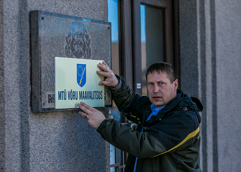 Andres Kõivu sõnul pole selles midagi imelikku, kui mittetulunduslik tegevus toimub regionaalse haldamise teel, see on ka riigi poolt tunnustatud – näiteks maakondade omavalitsusliidud tegutsevad MTÜdena. Pilt hetkest, mil Andres Kõiv paigaldab maavalitsuse hoonele MTÜ Võru Maavalitsus silti. 	Foto: ANDREI JAVNAŠAN