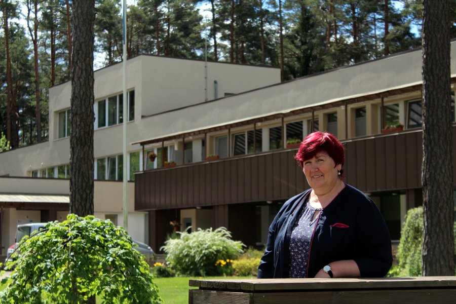 Tiiu Liloson, kelle suure palumise peale siiski pildile saime. Tagasihoidlik naine seisab oma töökoha ees, kus ta on töötanud viimased seitse aastat. Foto: AIGAR NAGEL