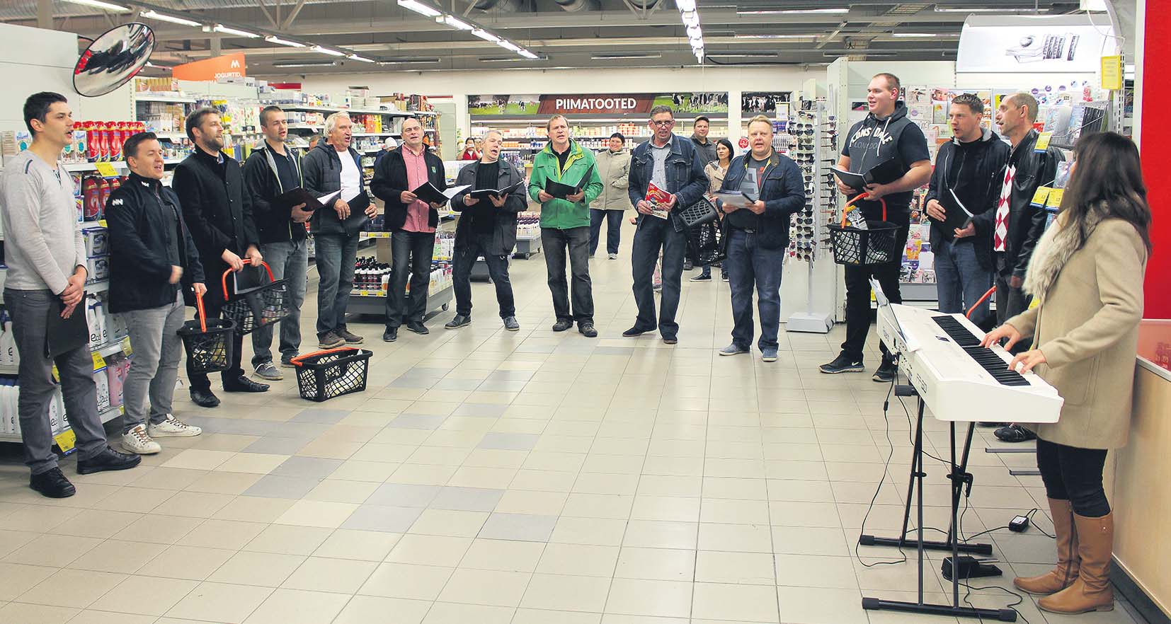 Lasva laulumehed pühapäeval tähistatud muusikapäeval Võru Maksimarketi riiulite vahel üllatuskontserti andmas. Pildil vasakult kolmas Lasva vallavanem Juris Juhansoo. Viis aastat tagasi loodud ansamblist on praeguseks välja kasvanud kahekümneliikmeline meeskoor, mehi juhendab Võrus elav Jane Reiljan. Fotod: TOMI SALUVEER