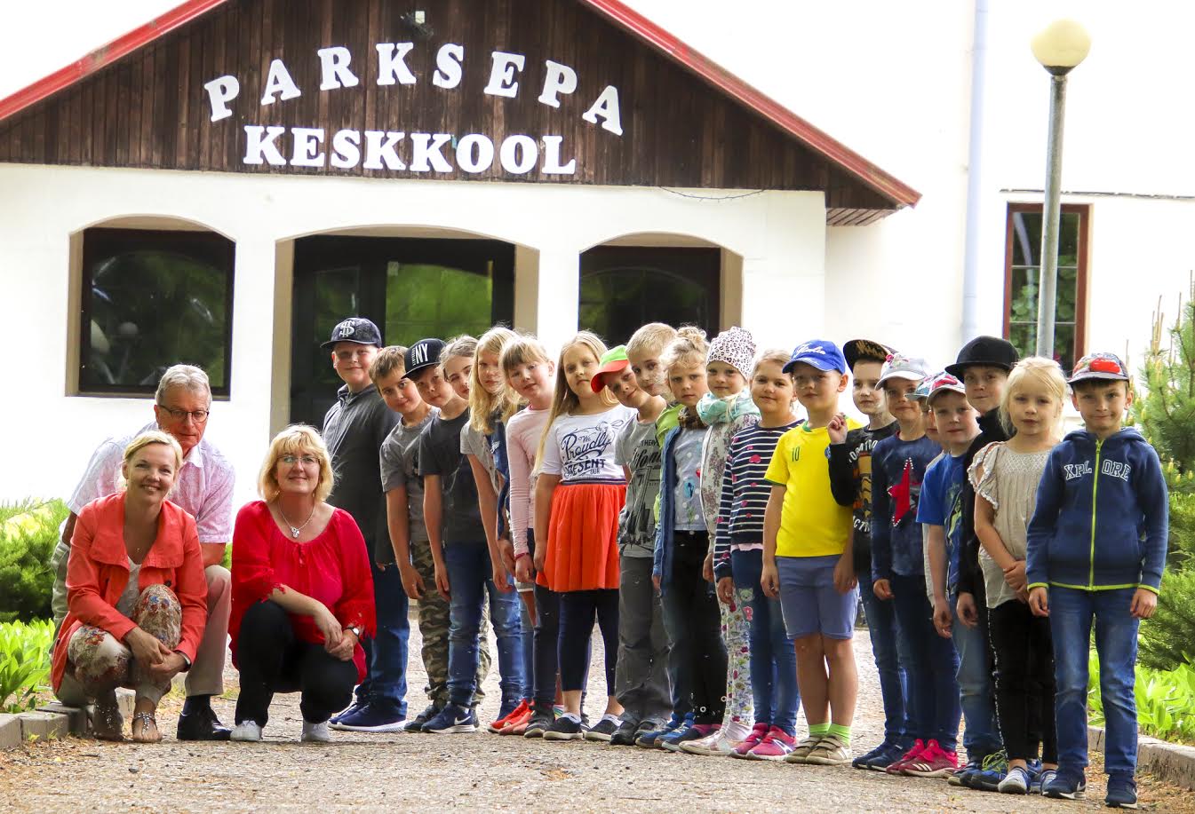 Parksepa keskkooli huvijuht Airi Pütsep (vasakult) ja 1. klassi klassijuhataja Ene Kärg koos direktori Ilmar Kesselmanni ja Parksepa keskkooli esimese klassi õpilastega eile hommikul kooli ees. „Me oleme kindlasti erilised ja see meid ka finaali viis!” kirjeldab Pütsep kooliperet. Foto: AIGAR NAGEL