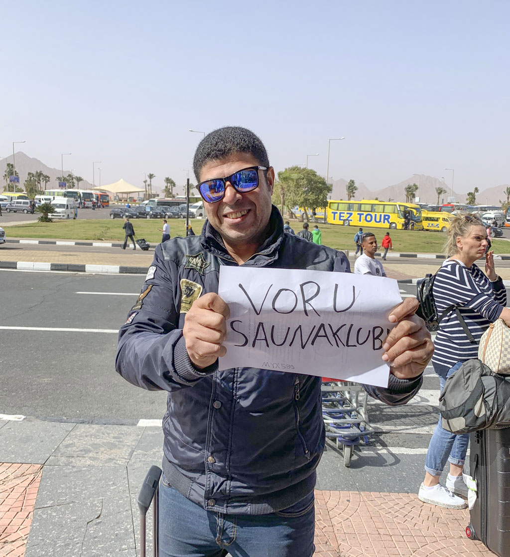 Võru saunaklubilasi võttis Sharm El Sheikhi lennujaamas vastu rõõmsameelne Ahmed, kelle käes olev plakat tegi pärast pikka lennureisi klubilaste tuju eriti heaks. Foto: ERAKOGU