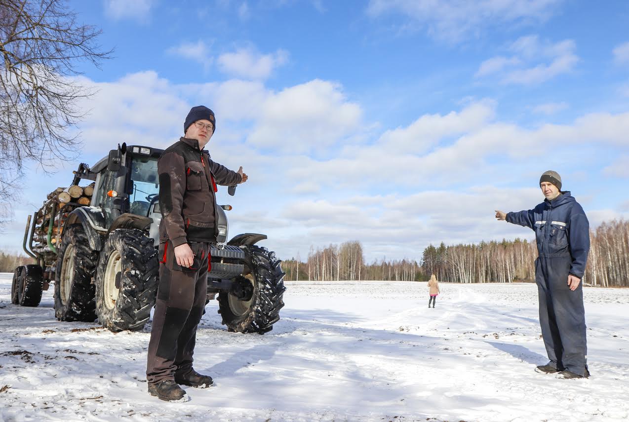 Alasilla talu peremees Teemar Kallaste (paremal) ja Raido Paat viitamas kohale, kus esmaspäeva hommikul vanaprouat uitamas nähti. Kõrval traktor, mille putitamine mehi parasjagu hoovis ametis hoidis ja veel metsatööle minna ei lasknud. FOTO: Aigar Nagel