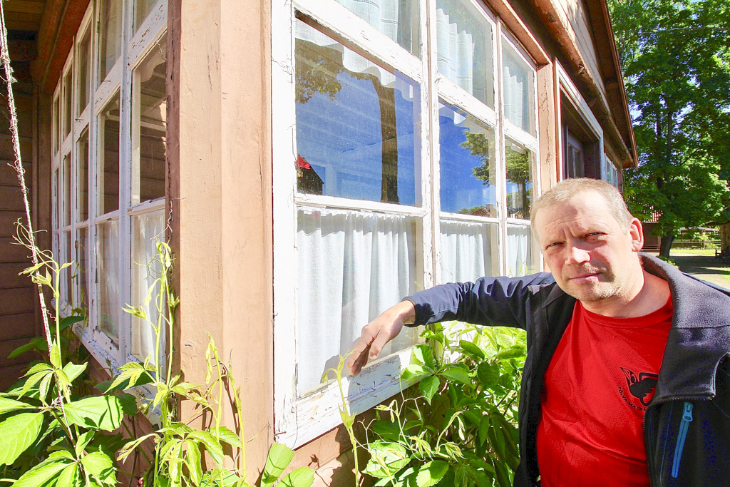 Meelis Maidla toonitab, et ei saa looduseta, matkamiseta, maratonidel osalemiseta ja muidugi puutööta. Pildil näitab ta, kuidas on muuseumi veranda aknaklaasid fikseeritud kitiga. Aknad võetakse eest ja sõidutatakse Põlvamaale Mammastesse, et kõik eeskujulikult korda teha, värvida ning kuivada lasta. Kvaliteetne restaureerimisel kasutatav värv kuivab kuni viis päeva. Foto: KALEV ANNOM
