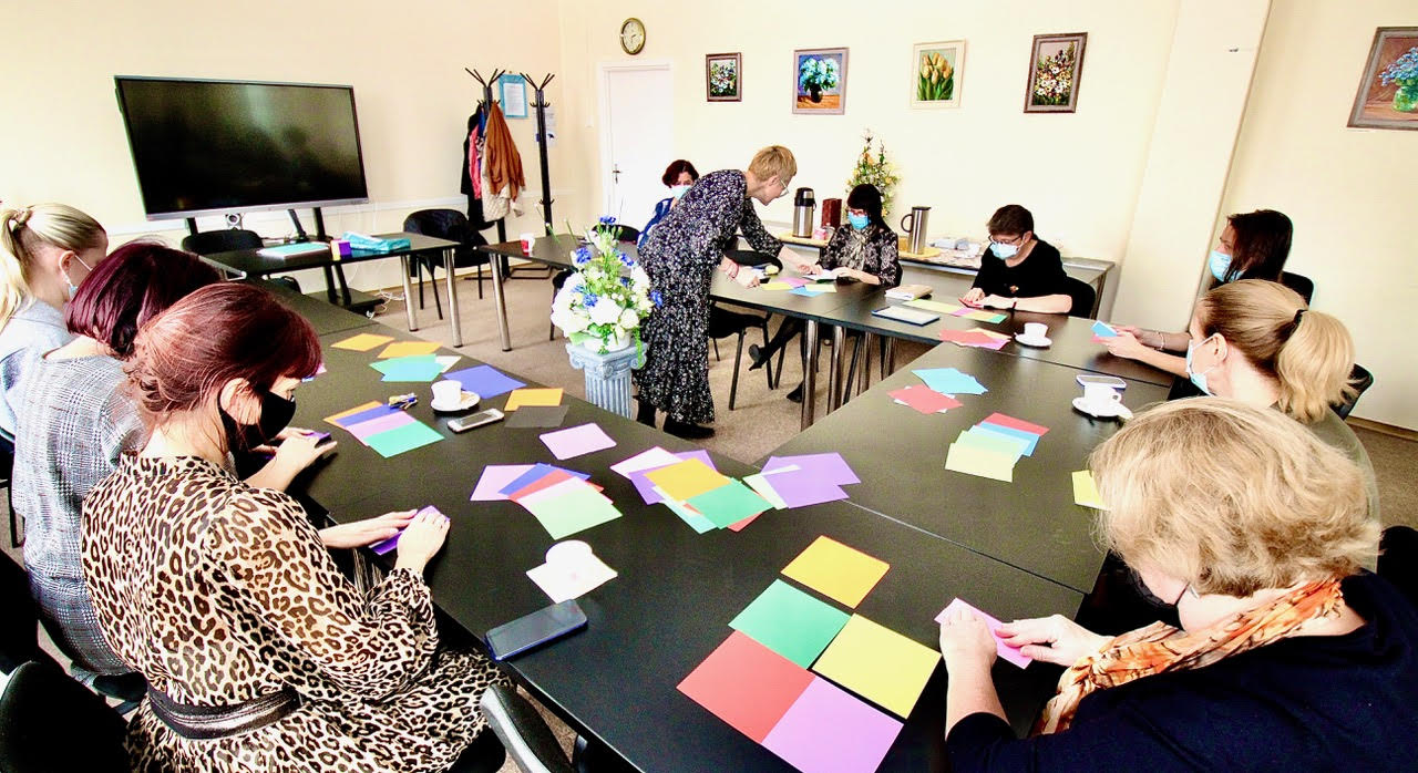 Värvilistest paberilehtedest kuubiku voltimine, kus laudade juures suunab voltijaid Tartu kõrgema kunstikooli skulptuuriosakonna  professor ning Eesti trüki- ja paberimuuseumi eestvedaja Anne Rudanovski. FOTOD: Kalev Annom