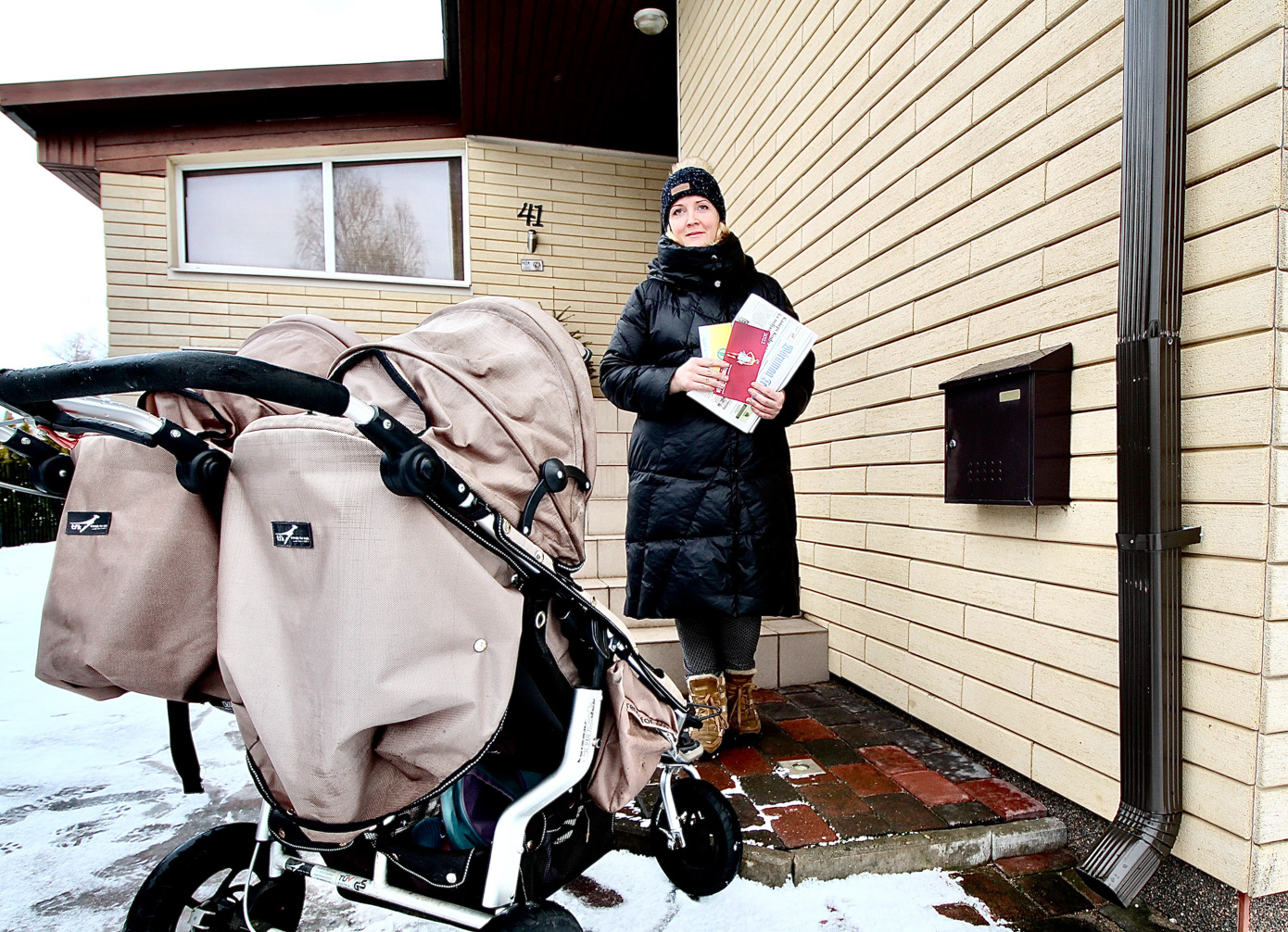 Nelja lapse ema Tagne Ilves oma kodumaja juures. Pildile jäi ka kaksikute Lenne ja Linda vanker. Kaksikud olid linnavanaema juures. Foto: KALEV ANNOM