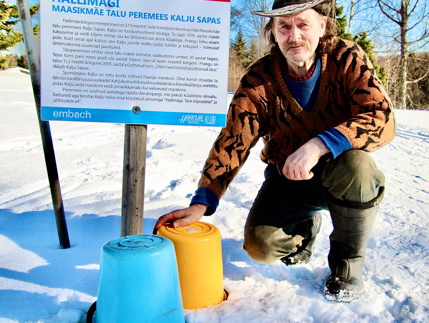 Kalju Sapas ja Ukraina lipu värvides ämbrid Haanjas suusaraja kõrval. Foto: KALEV ANNOM