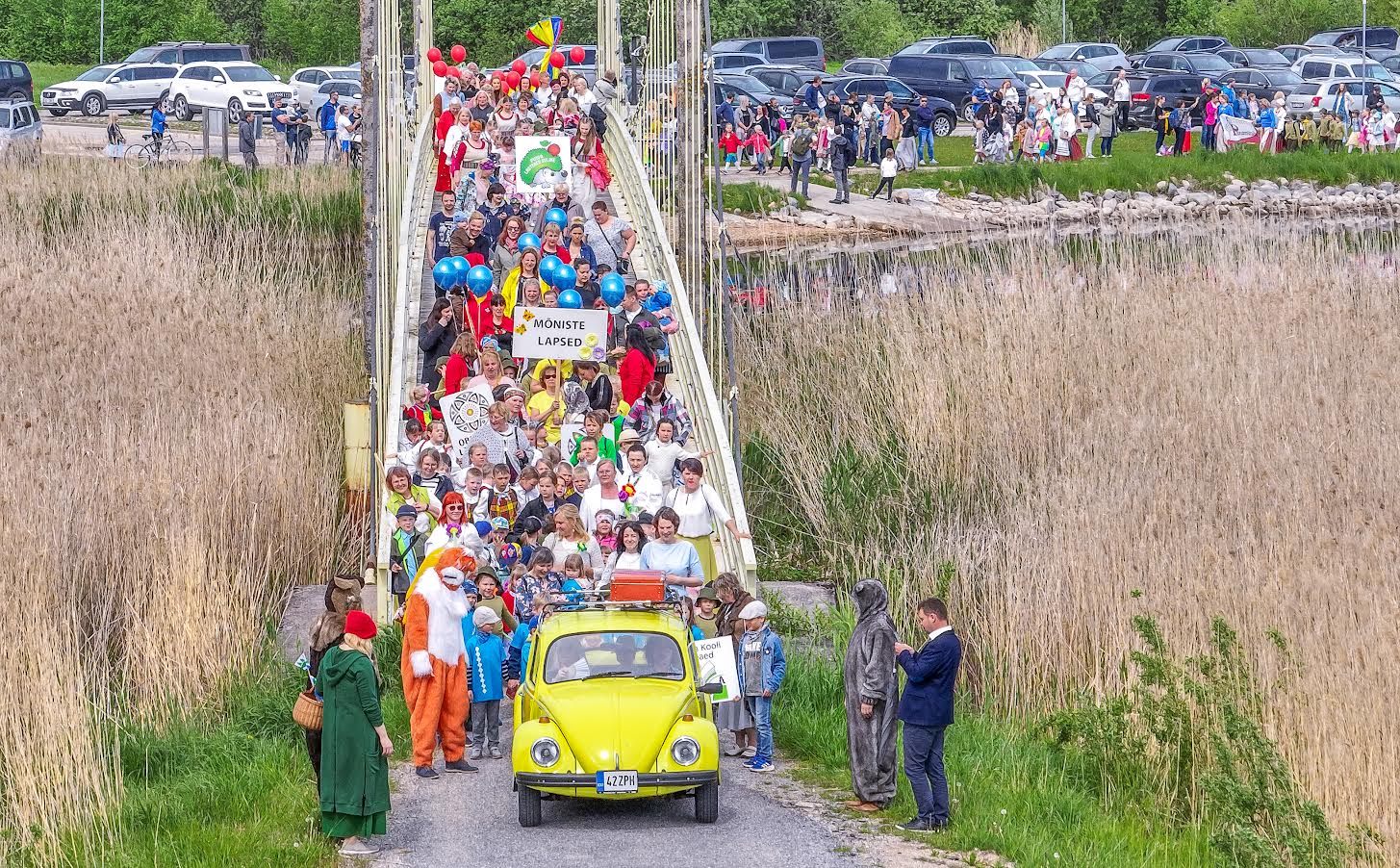 Kuuendale Võrumaa mudilaste laulu- ja tantsupeole eelnes ühine rongkäik, mis sai alguse Tamula rannapromenaadilt ja viis üle Roosisaare silla peo toimumispaika, Roosisaare vabaõhulavale. Mudilastest koosnev kirju ussisaba lookles pikalt mööda promenaadi nii kaugele, kui silm vaid ulatuda suutis. FOTO: Aigar Nagel