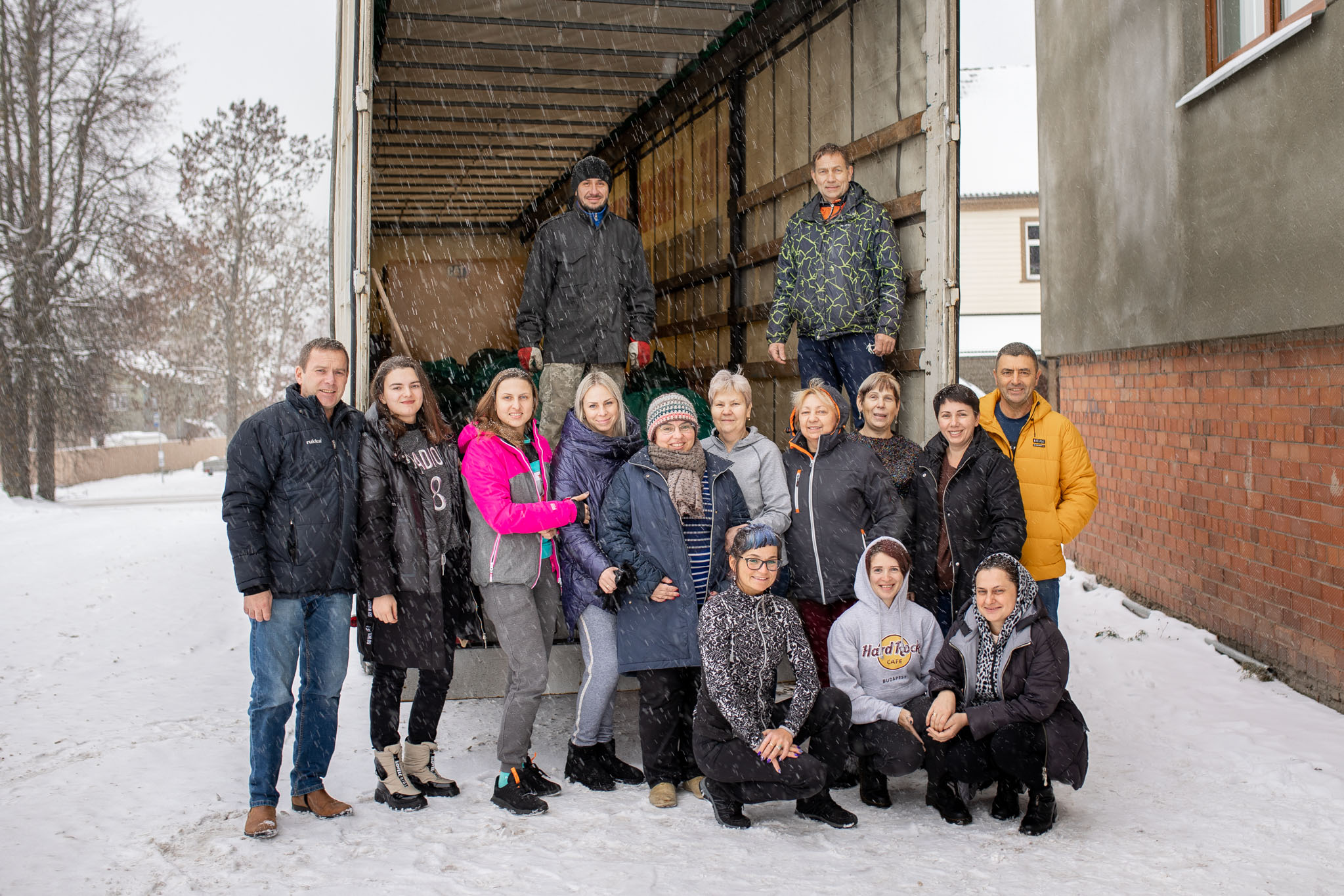 Piret Haljend (vasakult viies) oma eesti ja ukraina abilistega, kes pärast ühisfotot jätkasid abi pakkimist. Abilinnapea Sixten Sild ja autojuht Andrii Kovalchuk leidsid koha furgoonis. FOTOD: Aigar Nagel