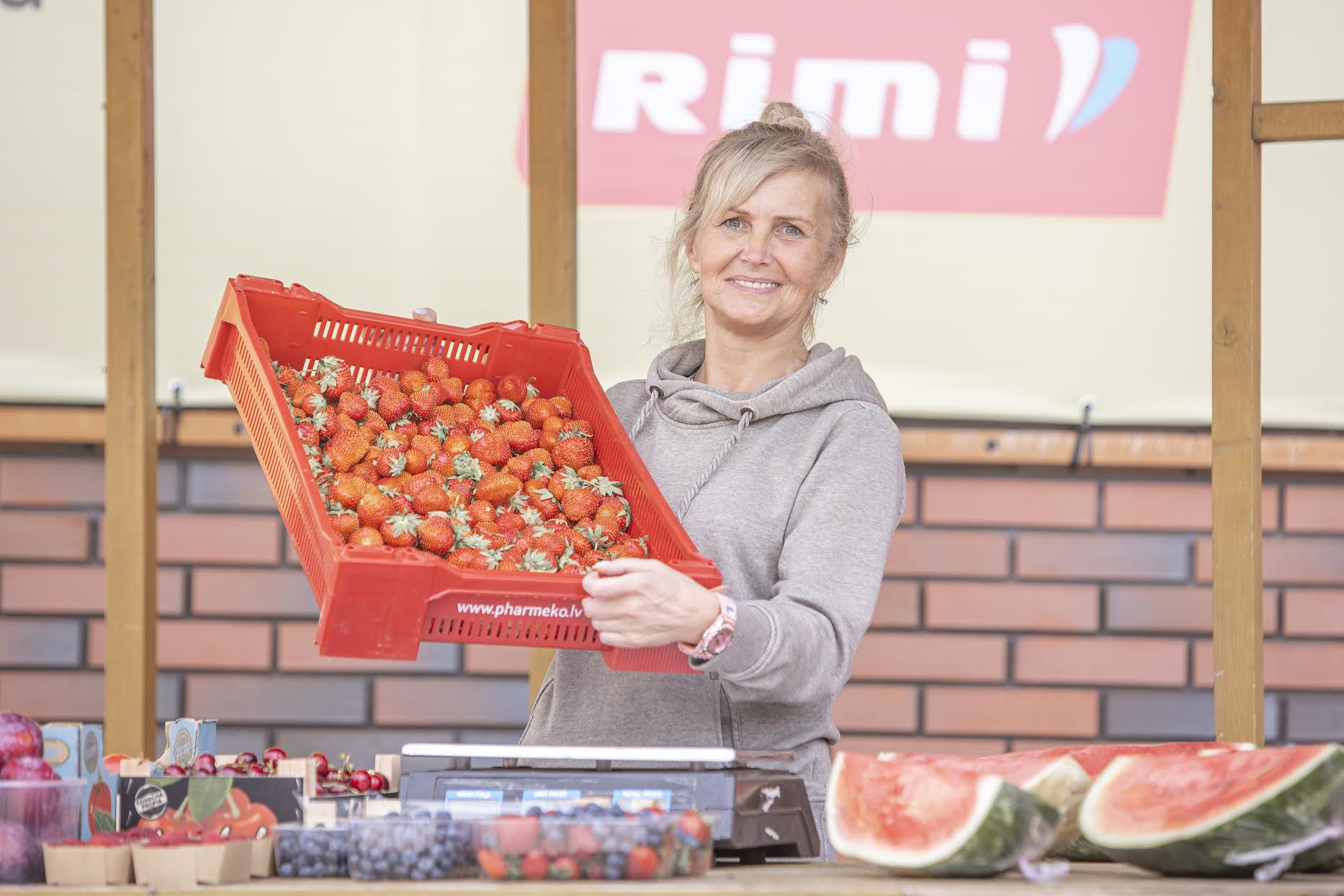 Kodumaine maasikas jõudis OÜ BerryMush lettidele kesknädalal. Neljapäeval sai Eesti maasikat osta 17eurose kilohinnaga  ja Kreeka päritolu marja 6,5eurose kilohinnaga. Rimi ees oleva müügileti taga tervitab ostjaid Tiina Hussar, kes müüb suviti  marju juba neljandat hooaega. Foto: AIGAR NAGEL