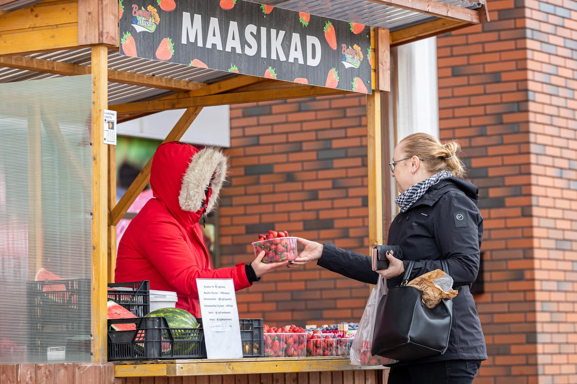 Kätlin-Kristin Lentsius Võru Rimi ees maasikaid müümas ja Esti Meier-Ahli kaupa ostmas. „Mina olen suur maasikaostja. Lastele väga maitsevad maasikad ja ostan kohe sellest ajast, kui esimesed maasikad poodidesse tulevad, veebruaris vist umbes. Eks mida suve poole, seda paremaks nad ajaga lähevad,” ütles Meier-Ahli. Foto: AIGAR NAGEL