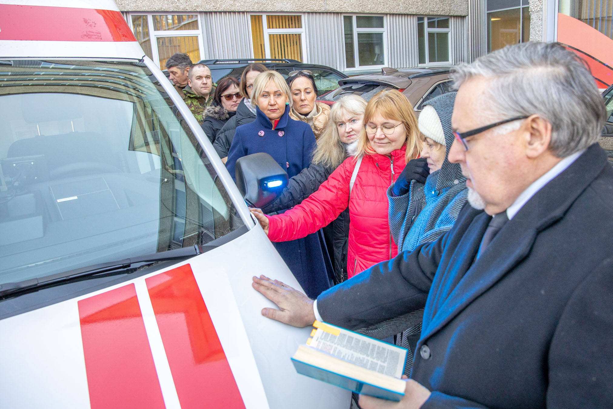 Esmaspäeva ennelõunal õnnistati kirikuõpetaja Jüri Pallo juhatamisel ja kõigi kohalviibijate abiga sisse mõlemad uued kiirabiautod. Selleks toetati käsi autole. FOTOD: Aigar Nagel