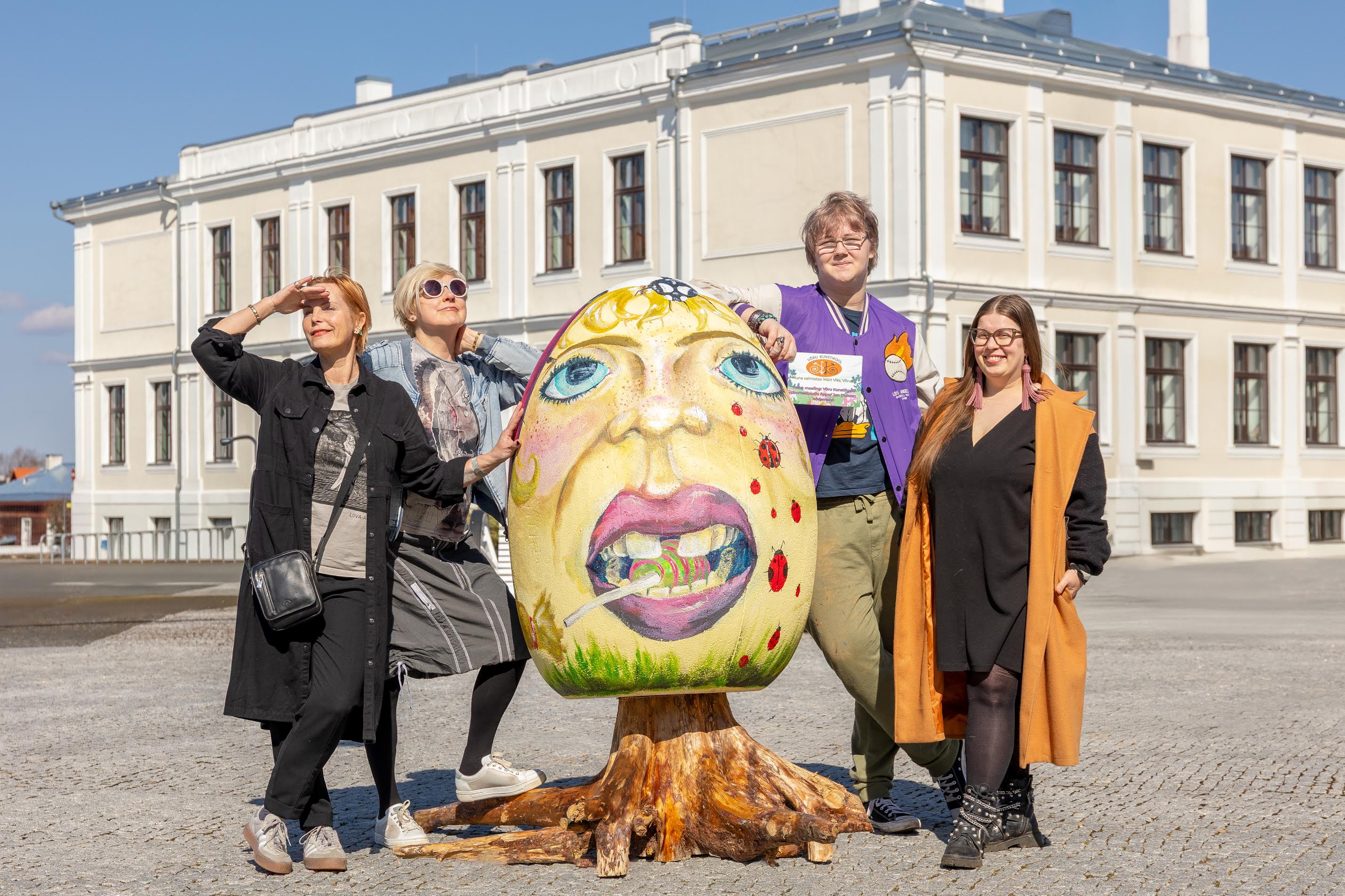 Võru kunstikooli õpetajad Triin Kristerson (vasakult), Urve Mill, õppur Jan Duncan Hödemann, Võru kunstikooli direktor Kristiina Rauba lapse ja lepatriinudega muna juures Võru keskväljakul. FOTO: Aigar Nagel