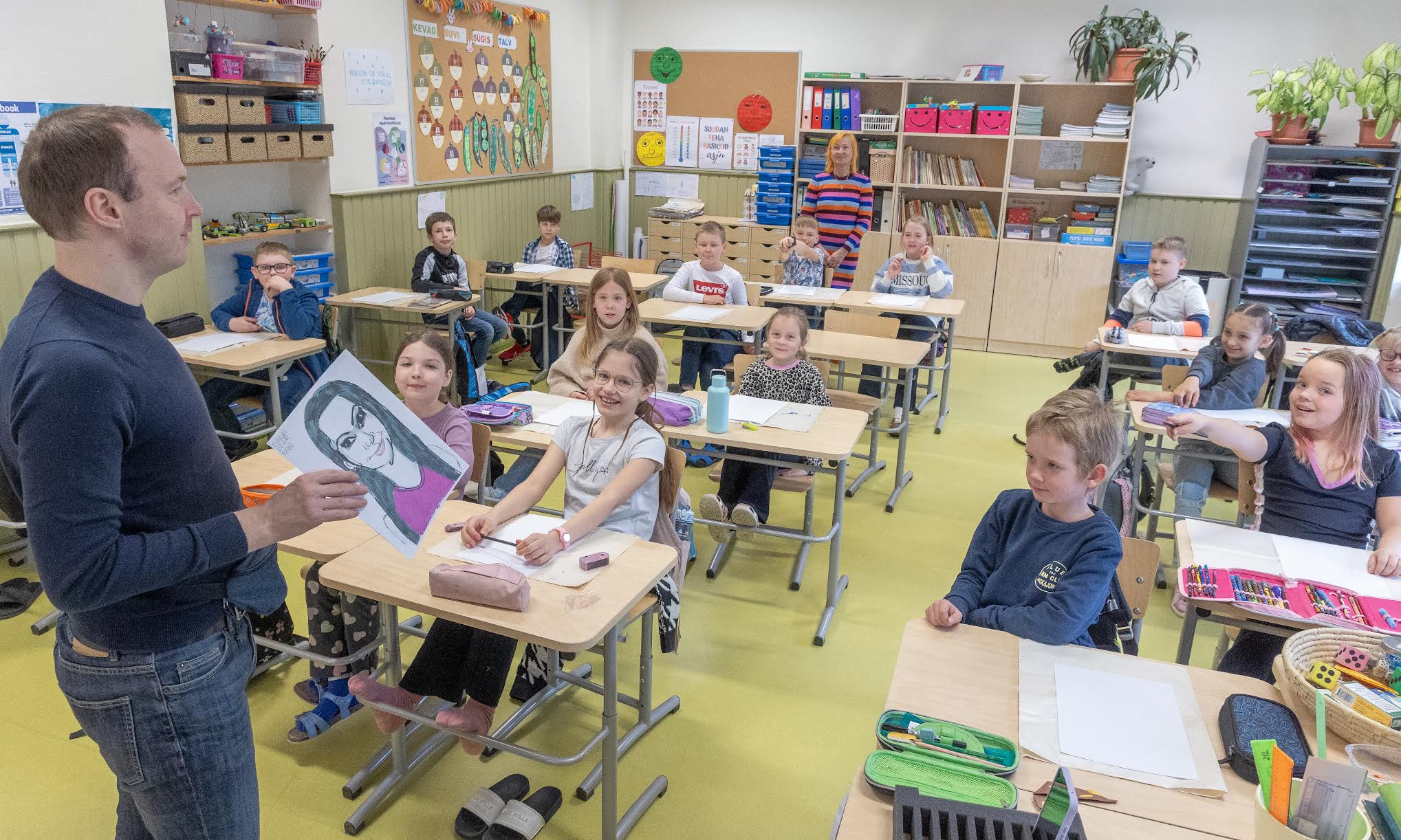 Kesklinna kooli 2.a klass sai peale teoreetiliste teadmiste käe soojaks proovides Kristjan Lume (esiplaanil) juhendamisel paberile panna Egle Eller-Nabi šarži. FOTOD: Aigar Nagel