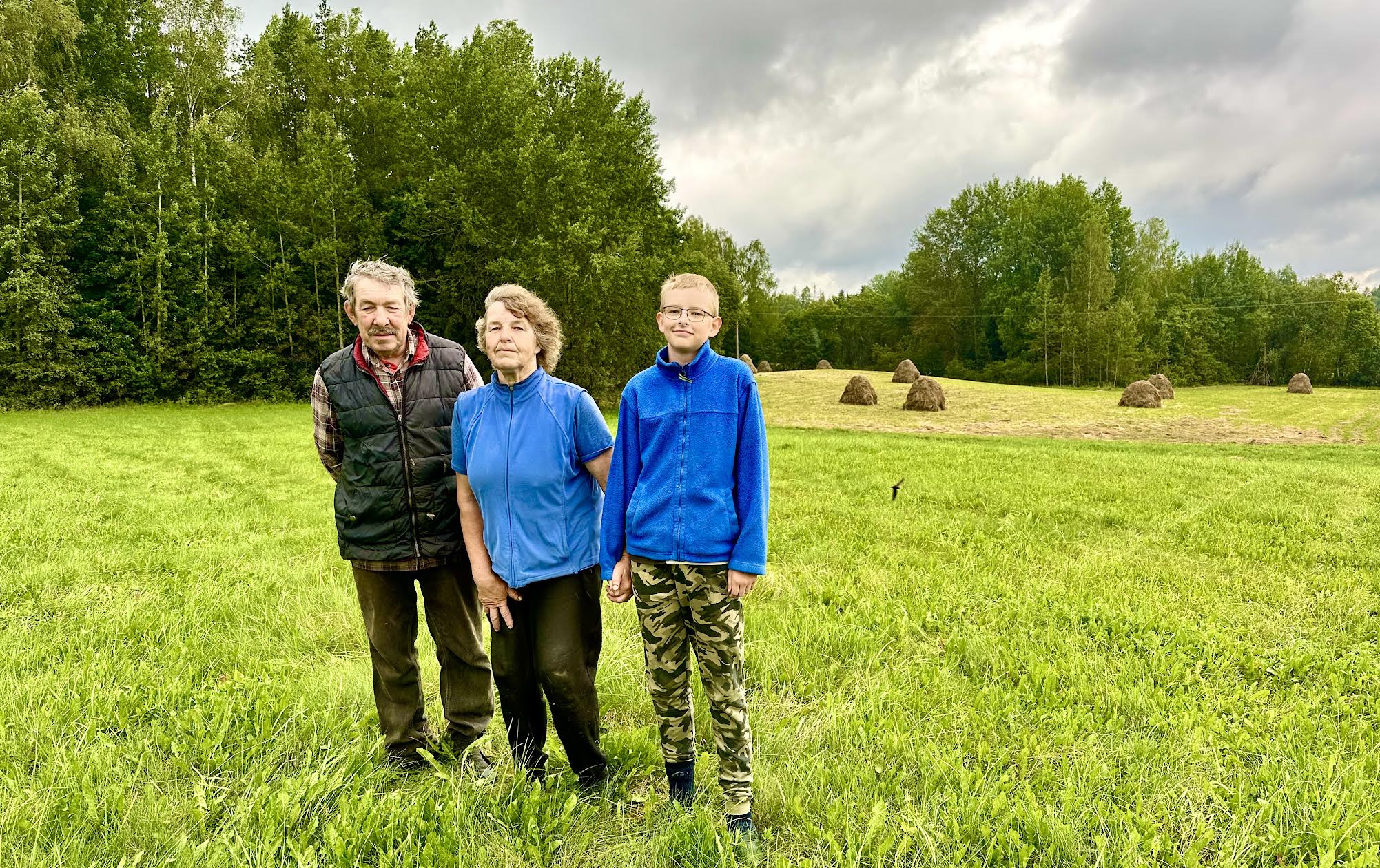 Koidu talu pere heinamaal. Lembit Sosare (vasakult), Aive Kullasepp ja Oliver Kullasepp. Taamal heinarõugud, mis ootavad küüni vedamist. Fotod: Kalev Annom