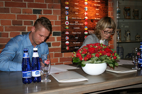 Aleksei Nikandrov kirjutab koos Tartu kultuurkapitali juhataja Anne Evrechtiga alla stipendiumilepingule. 	 Foto: VÕRUMAA  TEATAJA