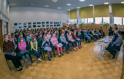 Antsla gümnaasiumi saali oli eile kirjanikega kohtuma tulnud umbes 160 Antsla ja Kuldre kooli last. Räägib Kätlin Vainola (seisab paremal laua taga). Saali tagaseinas on Antsla valla 25. sünnipäeva fotonäitus.  Foto: ANDREI JAVNAŠAN